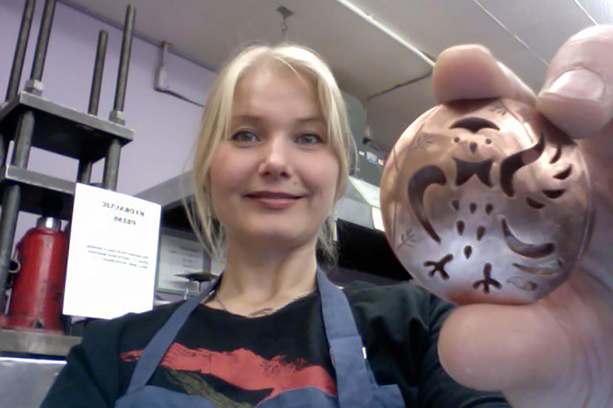 En kvinne sitter med en figur som ser ut som en ugle.