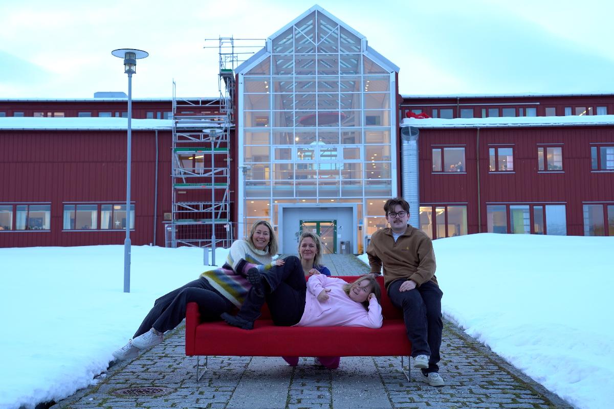 Fire personer sitter og ligger p&aring; en sofa.