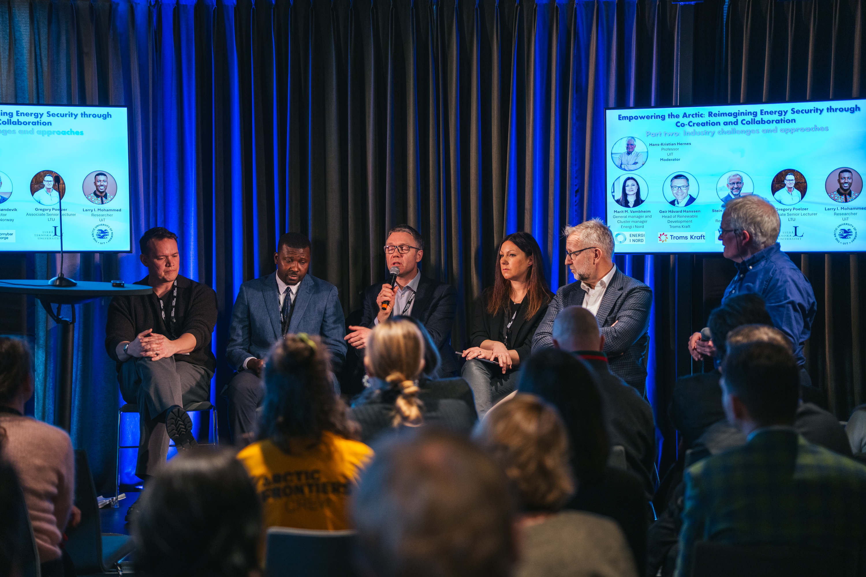 david-jensen-jensenmedia-00213_55074339665_o.jpg Folk som sitter på en scene og diskuterer, mellom to skjermer.