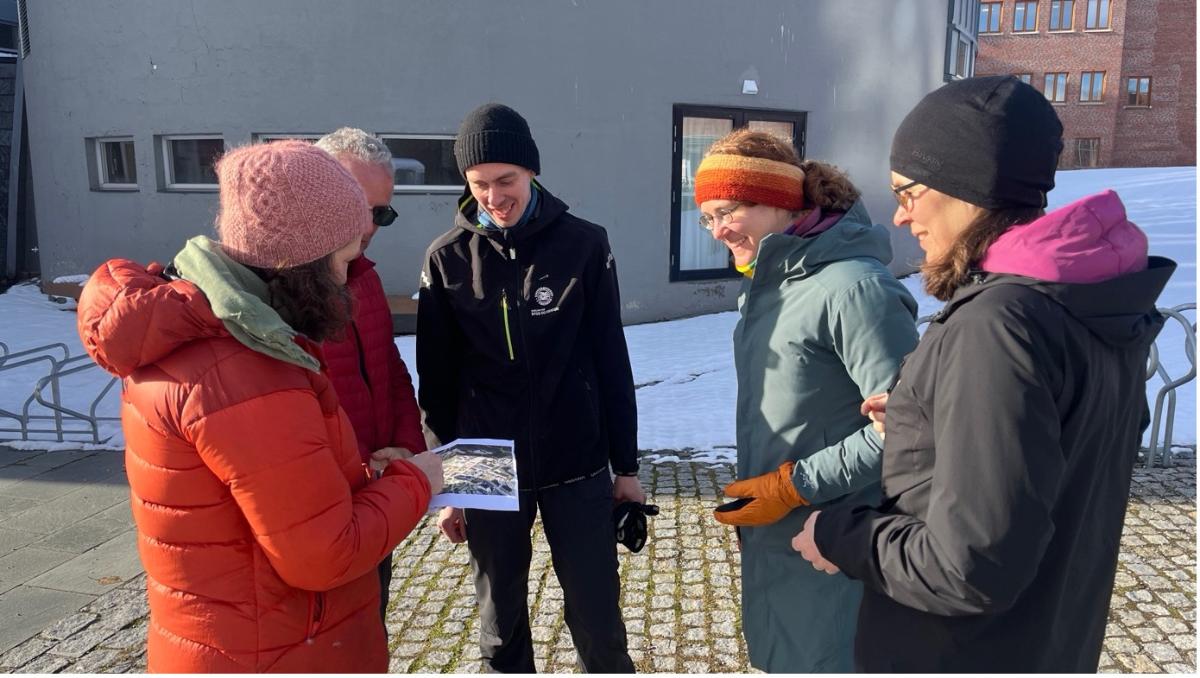 Fem personer som diskuter i sol framtiden p&aring; campus Breivika