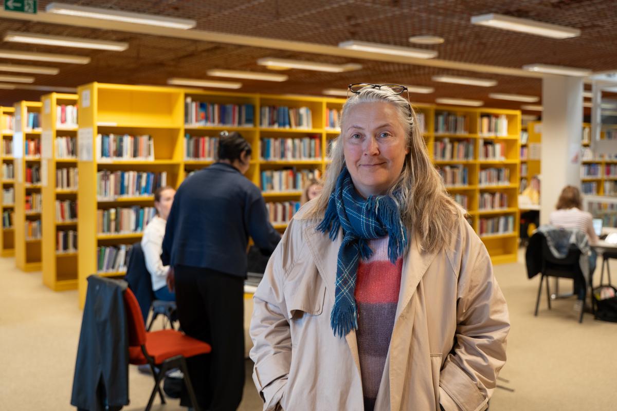 Kvinnelig bibliotekdirekt&oslash;r inne p&aring; et folksomt bibliotek. 